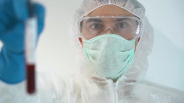 Sıhhiyecilerden biri Sputnik V aşısını kullandıktan sonra virüs testi negatif çıkmış. Koruyucu beyaz takım elbise giyen, maske takan, gözlük takan, mavi lastik eldiven takan bir sağlık görevlisi. Seçici odak
