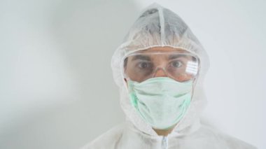 Hasta adam, tıbbi tetkikçi ilaç ya da aşı üzerinde çalışıyor, koruyucu giysi giyiyor. Laboratuvar asistanı üzerinde 2019-nCoV yazan bir tüp kan gösteriyor. Beyaz hastane geçmişi