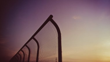 Manzara demir çit silueti, sıcak, klasik, sarı, günbatımı, gökyüzü, soyut arkaplan. Akşamları gökyüzü mor olur. Doğadaki manzara. Duvar kâğıdı için güzel görkemli gökyüzü.