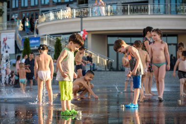 Kiev, Ukrayna 13 Ağustos 2017: Happy kids sıcak yaz gününde şehir su fıskiyede oynamak eğlenceli. Ebeveynler çocuklarıyla birlikte. Etkin aile boş, ekoloji kavramı.