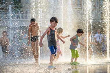 Kiev, Ukrayna 13 Ağustos 2017: Happy kids sıcak yaz gününde şehir su fıskiyede oynamak eğlenceli. Ebeveynler çocuklarıyla birlikte. Etkin aile boş, ekoloji kavramı.