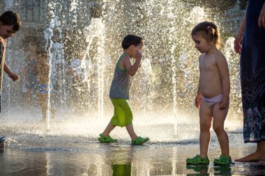 Kiev, Ukrayna 13 Ağustos 2017: Happy kids sıcak yaz gününde şehir su fıskiyede oynamak eğlenceli. Ebeveynler çocuklarıyla birlikte. Etkin aile boş, ekoloji kavramı.