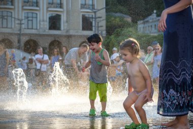 Kiev, Ukrayna 13 Ağustos 2017: Happy kids sıcak yaz gününde şehir su fıskiyede oynamak eğlenceli. Ebeveynler çocuklarıyla birlikte. Etkin aile boş, ekoloji kavramı.