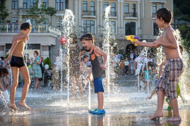 Kiev, Ukrayna 13 Ağustos 2017: Happy kids sıcak yaz gününde şehir su fıskiyede oynamak eğlenceli. Ebeveynler çocuklarıyla birlikte. Etkin aile boş, ekoloji kavramı.