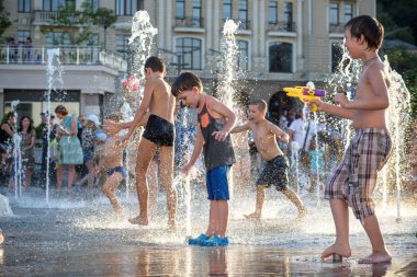 Kiev, Ukrayna 13 Ağustos 2017: Happy kids sıcak yaz gününde şehir su fıskiyede oynamak eğlenceli. Ebeveynler çocuklarıyla birlikte. Etkin aile boş, ekoloji kavramı.