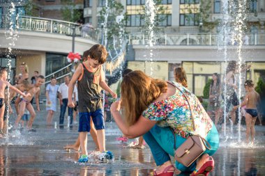 Kiev, Ukrayna 13 Ağustos 2017: Happy kids sıcak yaz gününde şehir su fıskiyede oynamak eğlenceli. Ebeveynler çocuklarıyla birlikte. Etkin aile boş, ekoloji kavramı.