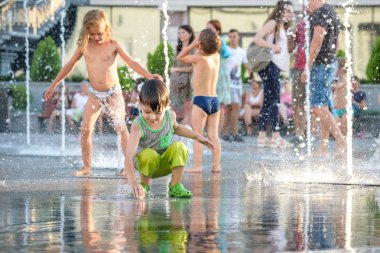 Kiev, Ukrayna 13 Ağustos 2017: Happy kids sıcak yaz gününde şehir su fıskiyede oynamak eğlenceli. Ebeveynler çocuklarıyla birlikte. Etkin aile boş, ekoloji kavramı.