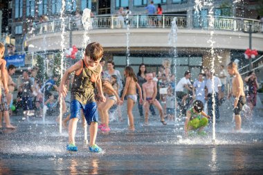 Kiev, Ukrayna 13 Ağustos 2017: Happy kids sıcak yaz gününde şehir su fıskiyede oynamak eğlenceli. Ebeveynler çocuklarıyla birlikte. Etkin aile boş, ekoloji kavramı.