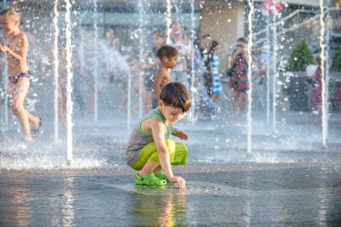 Kiev, Ukrayna 13 Ağustos 2017: Happy kids sıcak yaz gününde şehir su fıskiyede oynamak eğlenceli. Ebeveynler çocuklarıyla birlikte. Etkin aile boş, ekoloji kavramı.
