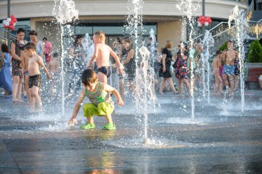 Kiev, Ukrayna 13 Ağustos 2017: Happy kids sıcak yaz gününde şehir su fıskiyede oynamak eğlenceli. Ebeveynler çocuklarıyla birlikte. Etkin aile boş, ekoloji kavramı.