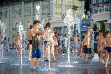Kiev, Ukrayna 13 Ağustos 2017: Happy kids sıcak yaz gününde şehir su fıskiyede oynamak eğlenceli. Ebeveynler çocuklarıyla birlikte. Etkin aile boş, ekoloji kavramı.