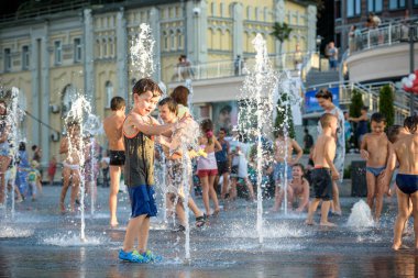 Kiev, Ukrayna 13 Ağustos 2017: Happy kids sıcak yaz gününde şehir su fıskiyede oynamak eğlenceli. Ebeveynler çocuklarıyla birlikte. Etkin aile boş, ekoloji kavramı.
