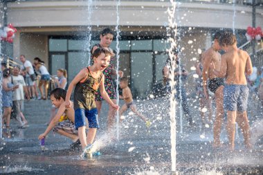 Kiev, Ukrayna 13 Ağustos 2017: Happy kids sıcak yaz gününde şehir su fıskiyede oynamak eğlenceli. Ebeveynler çocuklarıyla birlikte. Etkin aile boş, ekoloji kavramı.