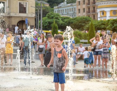 Kiev, Ukrayna 13 Ağustos 2017: Happy kids sıcak yaz gününde şehir su fıskiyede oynamak eğlenceli. Ebeveynler çocuklarıyla birlikte. Etkin aile boş, ekoloji kavramı.