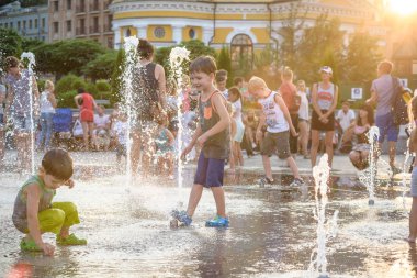 Kiev, Ukrayna 13 Ağustos 2017: Happy kids sıcak yaz gününde şehir su fıskiyede oynamak eğlenceli. Ebeveynler çocuklarıyla birlikte. Etkin aile boş, ekoloji kavramı.