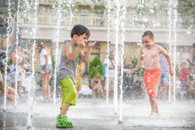 Kiev, Ukrayna 13 Ağustos 2017: Happy kids sıcak yaz gününde şehir su fıskiyede oynamak eğlenceli. Ebeveynler çocuklarıyla birlikte. Etkin aile boş, ekoloji kavramı.