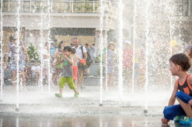 Kiev, Ukrayna 13 Ağustos 2017: Happy kids sıcak yaz gününde şehir su fıskiyede oynamak eğlenceli. Ebeveynler çocuklarıyla birlikte. Etkin aile boş, ekoloji kavramı.