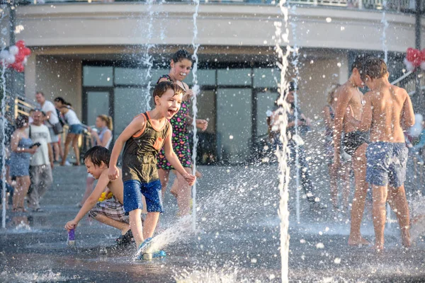 Kiev, Ukrayna 13 Ağustos 2017: Happy kids sıcak yaz gününde şehir su fıskiyede oynamak eğlenceli. Ebeveynler çocuklarıyla birlikte. Etkin aile boş, ekoloji kavramı.
