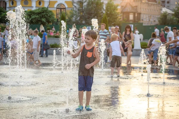 Kiev, Ukrayna 13 Ağustos 2017: Happy kids sıcak yaz gününde şehir su fıskiyede oynamak eğlenceli. Ebeveynler çocuklarıyla birlikte. Etkin aile boş, ekoloji kavramı.