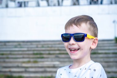 Korkmuş şaşırmış şaşkın karışık beyaz erkek çocuk güneş gözlüklü, tuğla beyaz duvar arka planı teşkil etmektedir. Beyaz çocuk modelleri açık havada heyecanlı.