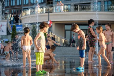 Kiev, Ukrayna 13 Ağustos 2017: Happy kids sıcak yaz gününde şehir su fıskiyede oynamak eğlenceli. Ebeveynler çocuklarıyla birlikte. Etkin aile boş, ekoloji kavramı.