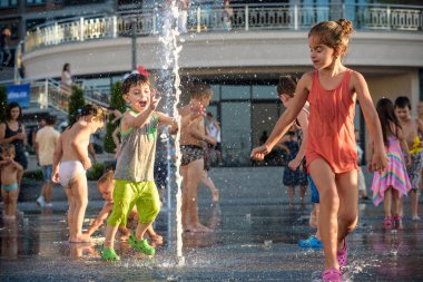 Kiev, Ukrayna 13 Ağustos 2017: Happy kids sıcak yaz gününde şehir su fıskiyede oynamak eğlenceli. Ebeveynler çocuklarıyla birlikte. Etkin aile boş, ekoloji kavramı.