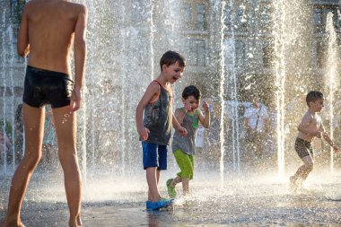 Kiev, Ukrayna 13 Ağustos 2017: Happy kids sıcak yaz gününde şehir su fıskiyede oynamak eğlenceli. Ebeveynler çocuklarıyla birlikte. Etkin aile boş, ekoloji kavramı.