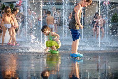 Kiev, Ukrayna 13 Ağustos 2017: Happy kids sıcak yaz gününde şehir su fıskiyede oynamak eğlenceli. Ebeveynler çocuklarıyla birlikte. Etkin aile boş, ekoloji kavramı.