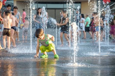 Kiev, Ukrayna 13 Ağustos 2017: Happy kids sıcak yaz gününde şehir su fıskiyede oynamak eğlenceli. Ebeveynler çocuklarıyla birlikte. Etkin aile boş, ekoloji kavramı.
