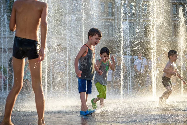 Kiev, Ukrayna 13 Ağustos 2017: Happy kids sıcak yaz gününde şehir su fıskiyede oynamak eğlenceli. Ebeveynler çocuklarıyla birlikte. Etkin aile boş, ekoloji kavramı.