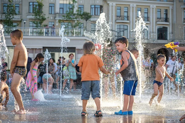 Kiev, Ukrayna 13 Ağustos 2017: Happy kids sıcak yaz gününde şehir su fıskiyede oynamak eğlenceli. Ebeveynler çocuklarıyla birlikte. Etkin aile boş, ekoloji kavramı.