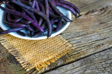 Ahşap ahşap arka plan tabağa mor dize fasulye.