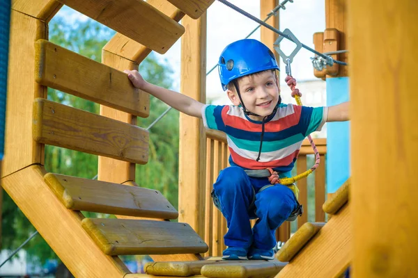 Eğleniyor ve Macera Parkı'nda oynarken, ipleri tutan ve Ahşap merdiven çıkma mutlu çocuk.