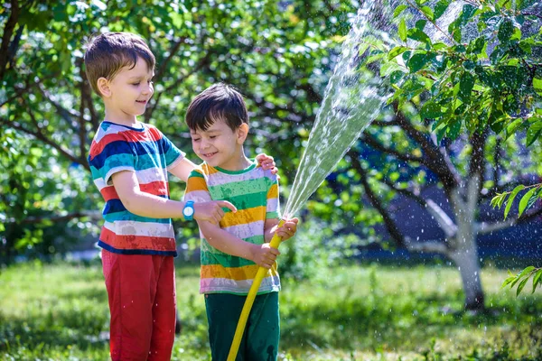 Niño Feliz Vierte Agua Una Manguera Los Niños Divierten Con —  Fotos de Stock