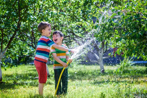 Milý Chlapeček Zalévání Rostlin Zavlažovací Hadice Zahradě Roztomilé Malé Dítě — Stock fotografie