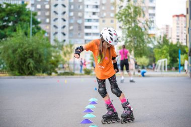 Kiev, Ukrayna 26 Haziran 2018: silindir bıçaklar lanmış bir kırsal yolda hızda viraj kollarını uçan yuvarlama üzerinde çekici genç kız paten