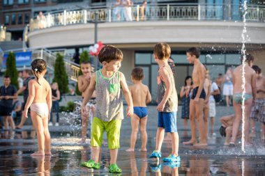 Kiev, Ukrayna 13 Ağustos 2017: Happy kids sıcak yaz gününde şehir su fıskiyede oynamak eğlenceli. Ebeveynler çocuklarıyla birlikte. Etkin aile boş, ekoloji kavramı.