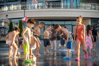 Kiev, Ukrayna 13 Ağustos 2017: Happy kids sıcak yaz gününde şehir su fıskiyede oynamak eğlenceli. Ebeveynler çocuklarıyla birlikte. Etkin aile boş, ekoloji kavramı.