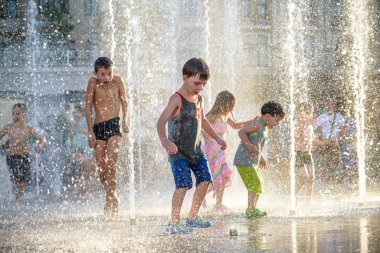 Kiev, Ukrayna 13 Ağustos 2017: Happy kids sıcak yaz gününde şehir su fıskiyede oynamak eğlenceli. Ebeveynler çocuklarıyla birlikte. Etkin aile boş, ekoloji kavramı.