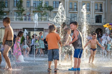 Kiev, Ukrayna 13 Ağustos 2017: Happy kids sıcak yaz gününde şehir su fıskiyede oynamak eğlenceli. Ebeveynler çocuklarıyla birlikte. Etkin aile boş, ekoloji kavramı.