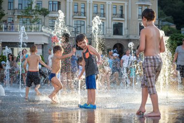 Kiev, Ukrayna 13 Ağustos 2017: Happy kids sıcak yaz gününde şehir su fıskiyede oynamak eğlenceli. Ebeveynler çocuklarıyla birlikte. Etkin aile boş, ekoloji kavramı.