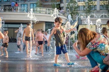 Kiev, Ukrayna 13 Ağustos 2017: Happy kids sıcak yaz gününde şehir su fıskiyede oynamak eğlenceli. Ebeveynler çocuklarıyla birlikte. Etkin aile boş, ekoloji kavramı.