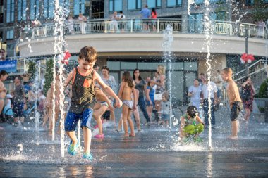 Kiev, Ukrayna 13 Ağustos 2017: Happy kids sıcak yaz gününde şehir su fıskiyede oynamak eğlenceli. Ebeveynler çocuklarıyla birlikte. Etkin aile boş, ekoloji kavramı.
