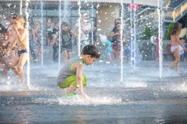 Kiev, Ukrayna 13 Ağustos 2017: Happy kids sıcak yaz gününde şehir su fıskiyede oynamak eğlenceli. Ebeveynler çocuklarıyla birlikte. Etkin aile boş, ekoloji kavramı.
