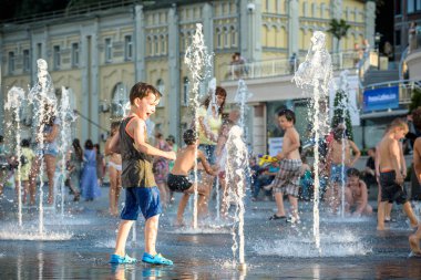 Kiev, Ukrayna 13 Ağustos 2017: Happy kids sıcak yaz gününde şehir su fıskiyede oynamak eğlenceli. Ebeveynler çocuklarıyla birlikte. Etkin aile boş, ekoloji kavramı.