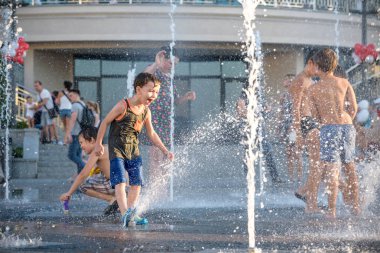 Kiev, Ukrayna 13 Ağustos 2017: Happy kids sıcak yaz gününde şehir su fıskiyede oynamak eğlenceli. Ebeveynler çocuklarıyla birlikte. Etkin aile boş, ekoloji kavramı.