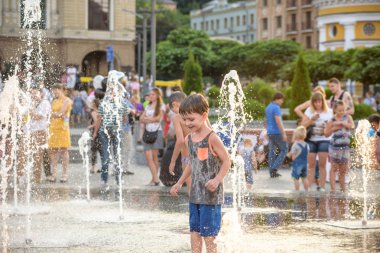 Kiev, Ukrayna 13 Ağustos 2017: Happy kids sıcak yaz gününde şehir su fıskiyede oynamak eğlenceli. Ebeveynler çocuklarıyla birlikte. Etkin aile boş, ekoloji kavramı.