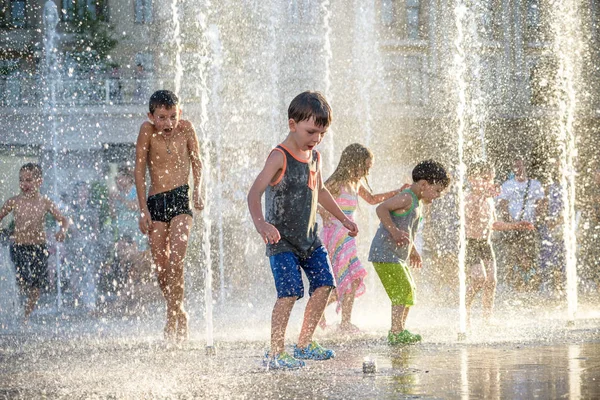 Kiev, Ukrayna 13 Ağustos 2017: Happy kids sıcak yaz gününde şehir su fıskiyede oynamak eğlenceli. Ebeveynler çocuklarıyla birlikte. Etkin aile boş, ekoloji kavramı.