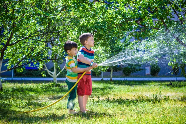 Dos Amiguitos Jugando Juntos Salpicando Con Una Manguera Jardín Caluroso —  Fotos de Stock