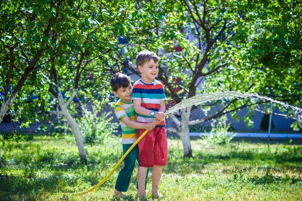 Dois Amiguinhos Brincando Juntos Salpicando Com Uma Mangueira Jardim Dia — Fotografia de Stock